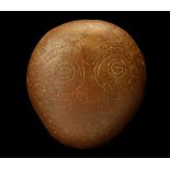 A NATIVE AMERICAN ENGRAVED RITUAL STONE Decorated with an abstract face with large round eyes and