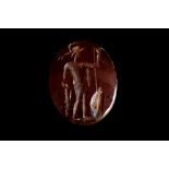 A ROMAN CARNELIAN INTAGLIO Circa 1st-3rd Century A.D. The oval gem engraved with a soldier wearing a