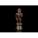 A KONGO FIGURE, DEMOCRATIC REPUBLIC OF CONGO Depicting a man seated on a stool, wearing the