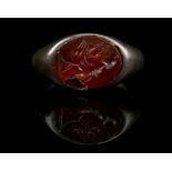 A ROMAN SILVER AND CARNELIAN INTAGLIO RING Circa 1st-3rd Century A.D. The oval gem engraved with a