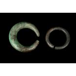TWO PERSIAN BRONZE TORCS Both solid-cast of penannular shape, with incised geometric decoration, the