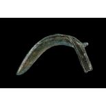 A EUROPEAN BRONZE SICKLE Late Bronze Age, circa 8th-7th Century B.C. Flat-backed, the curved blade