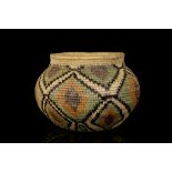 A POLYCHROME STRAW BOTTLENECK BASKET, CALIFORNIA Decorated with geometric patterns in green, purple,