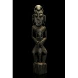 A BATAK FIGURE, SUMATRA, INDONESIA With a lizard over the head and holding another to its chest,