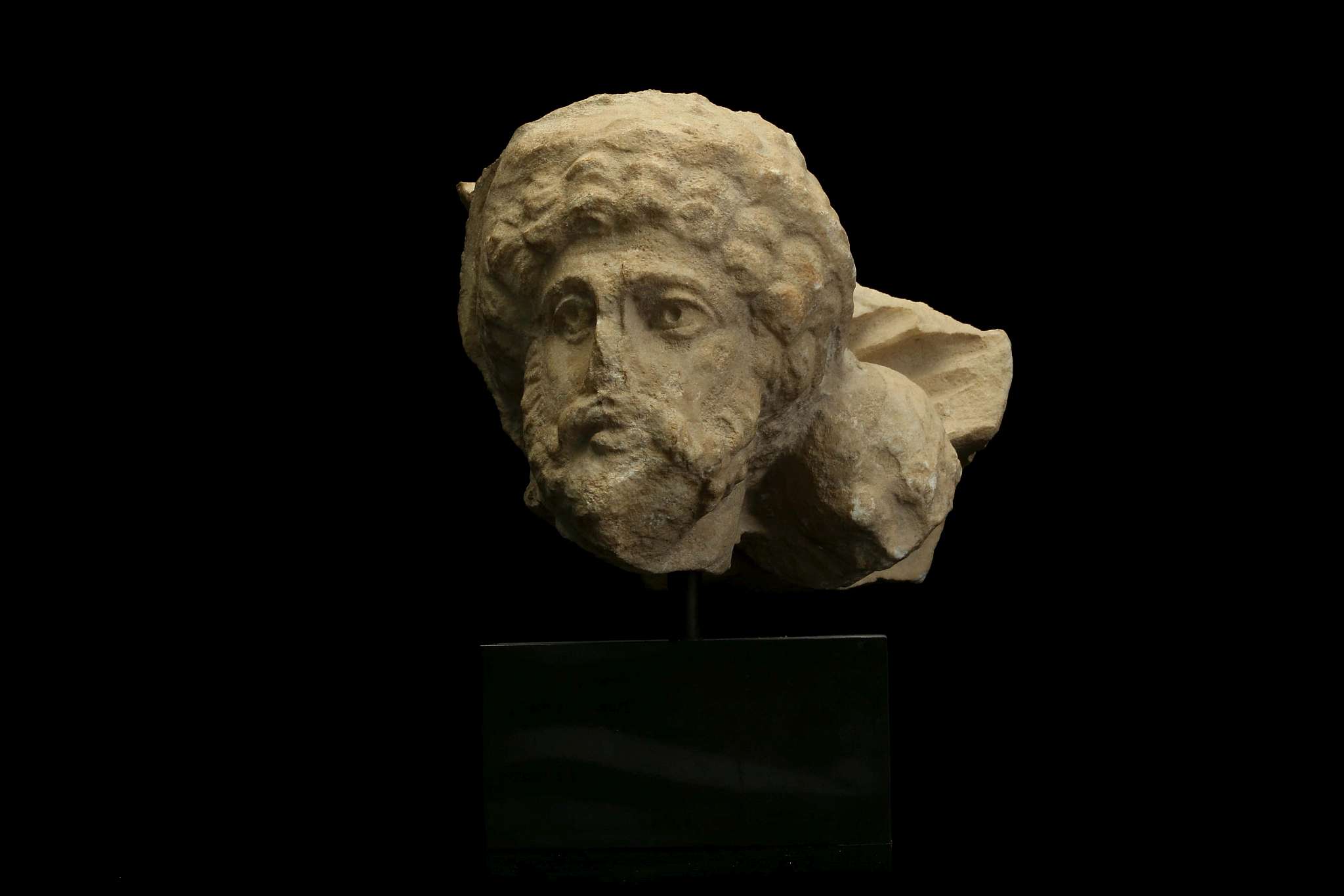 A ROMAN MARBLE SARCOPHAGUS FRAGMENT Circa early 3rd Century A.D. Depicting a male head with full