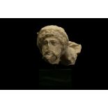 A ROMAN MARBLE SARCOPHAGUS FRAGMENT Circa early 3rd Century A.D. Depicting a male head with full