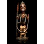 A YORUBA MALE SHRINE FIGURE, NIGERIA Riding on the back of a horse, holding a long spear and one