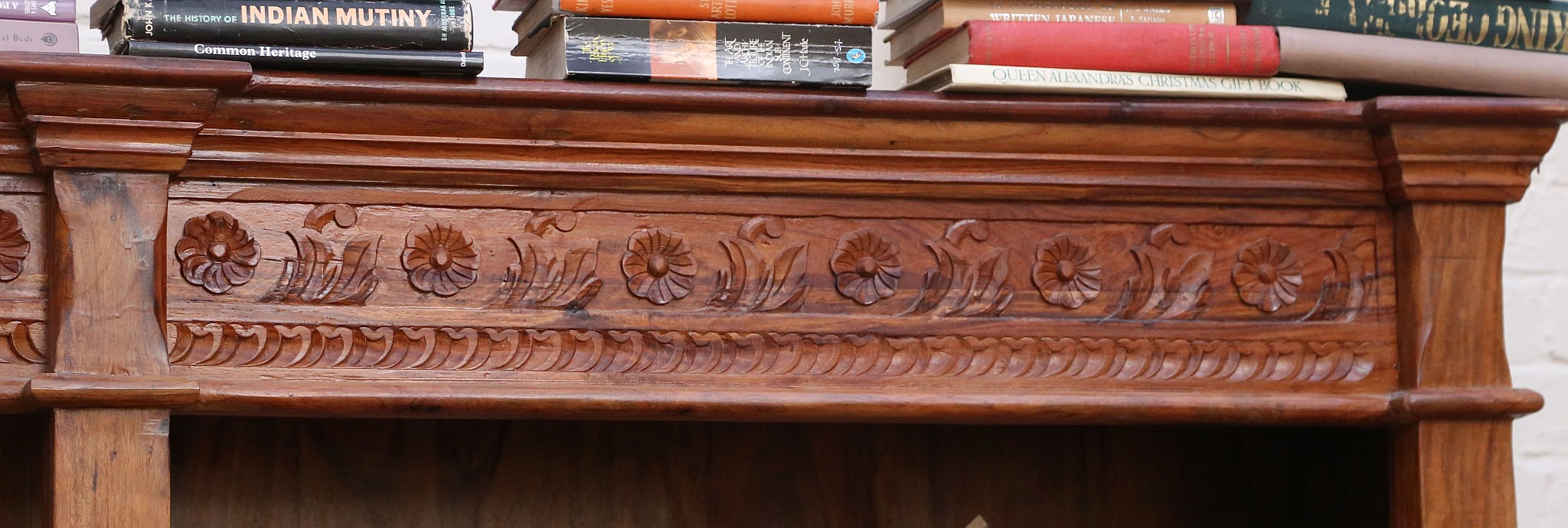 A 20th century, double front set of open bookcases in tropical hardwood and having a carved top - Image 3 of 3