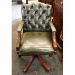 A green leather office chair, with button upholstered back over an upholstered seat flanked by