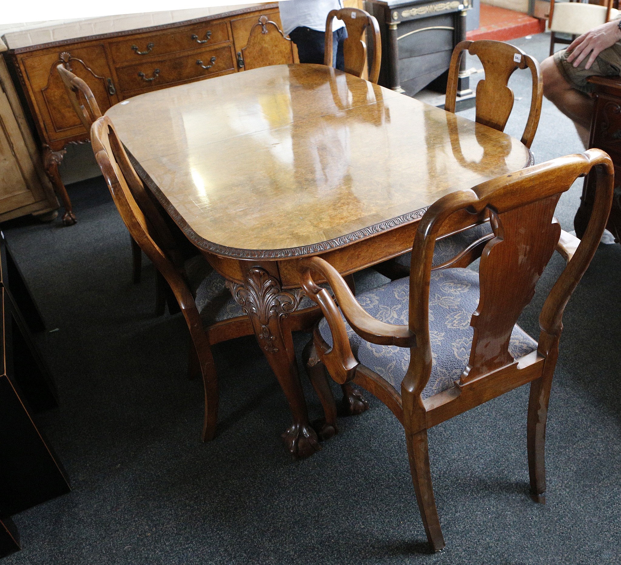 A burr walnut dining suite c.1950, comprising a table with leaf trim, acanthus carving to legs, ball