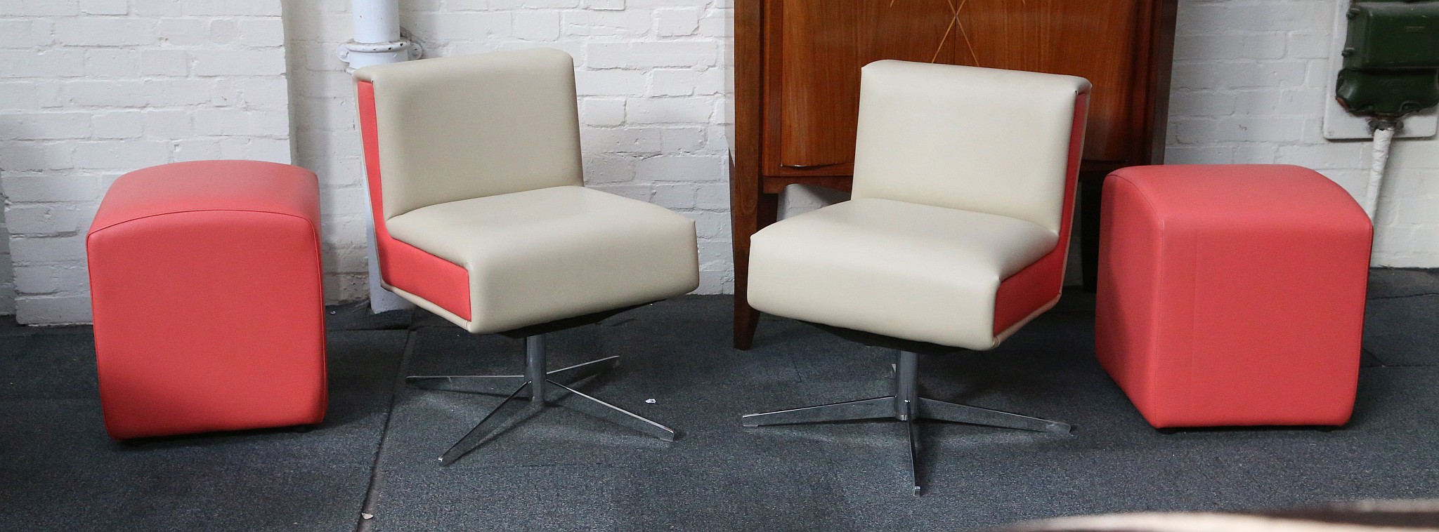 A PAIR OF MODERN SWIVEL LOUNGE CHAIRS AND FOOTSTOOL, designed and manufactured by HB Furniture, with