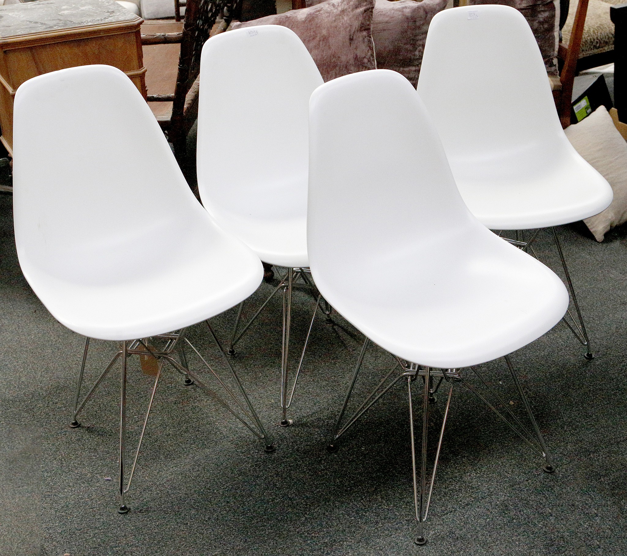 A set of four Eames inspired white Eiffel Tower chairs, 83 H x 47 W x 55cm deep.