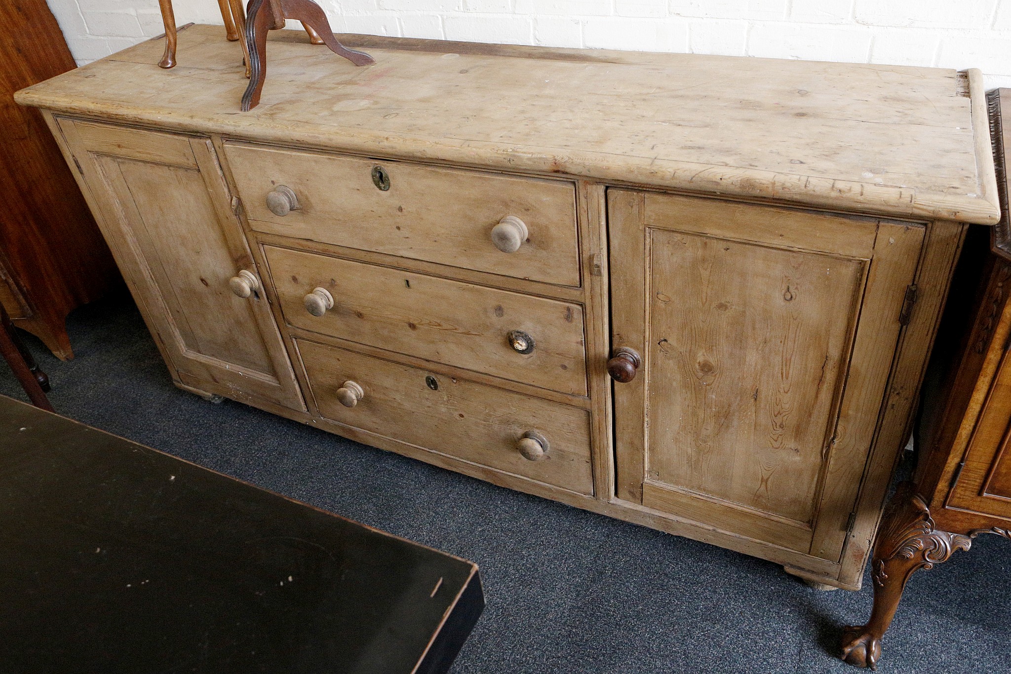 An early 20th century, Irish dresser base, pine, two cupboards flanking three drawers, 190cm wide.
