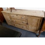 An early 20th century, Irish dresser base, pine, two cupboards flanking three drawers, 190cm wide.