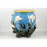 A Majolica style planter, lily and swallow decoration with 'plant' feet, 37cm diameter.