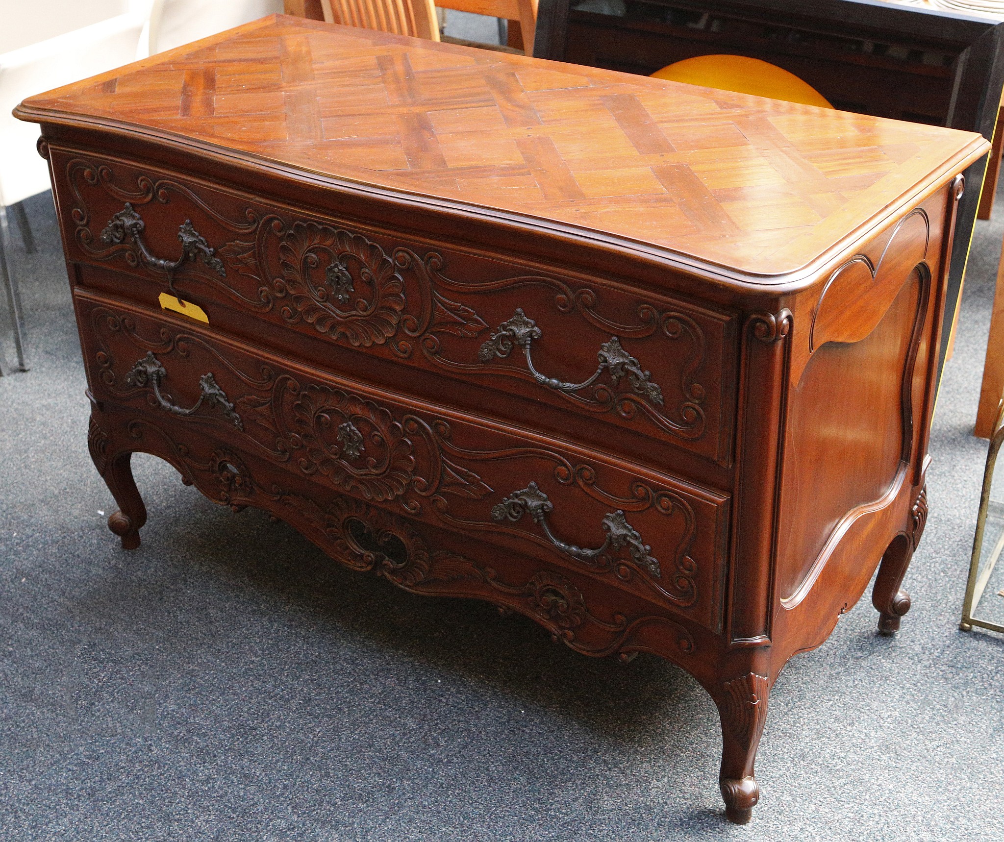 An early 20th century, rococo style serpentine front sideboard, having parquetry top and 2 carved