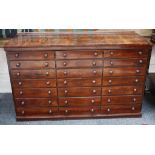 A Victorian mahogany bank of drawers, with three drawers across and seven down, on plinth base,
