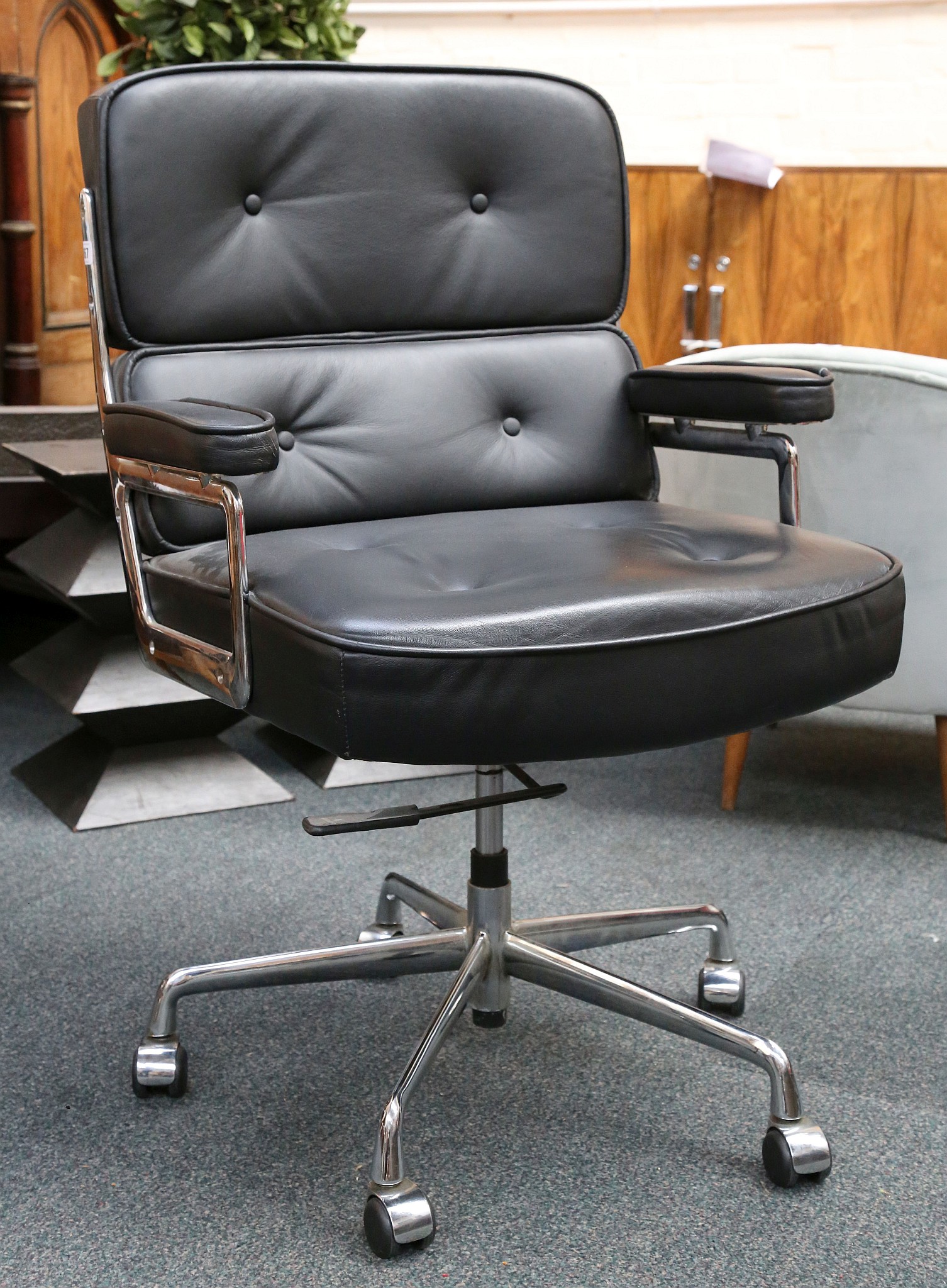 An Eames style, Time Life lobby chair in black leather and chrome with rise and fall action.