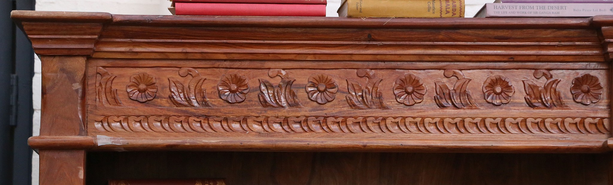 A 20th century, double front set of open bookcases in tropical hardwood and having a carved top - Image 2 of 3