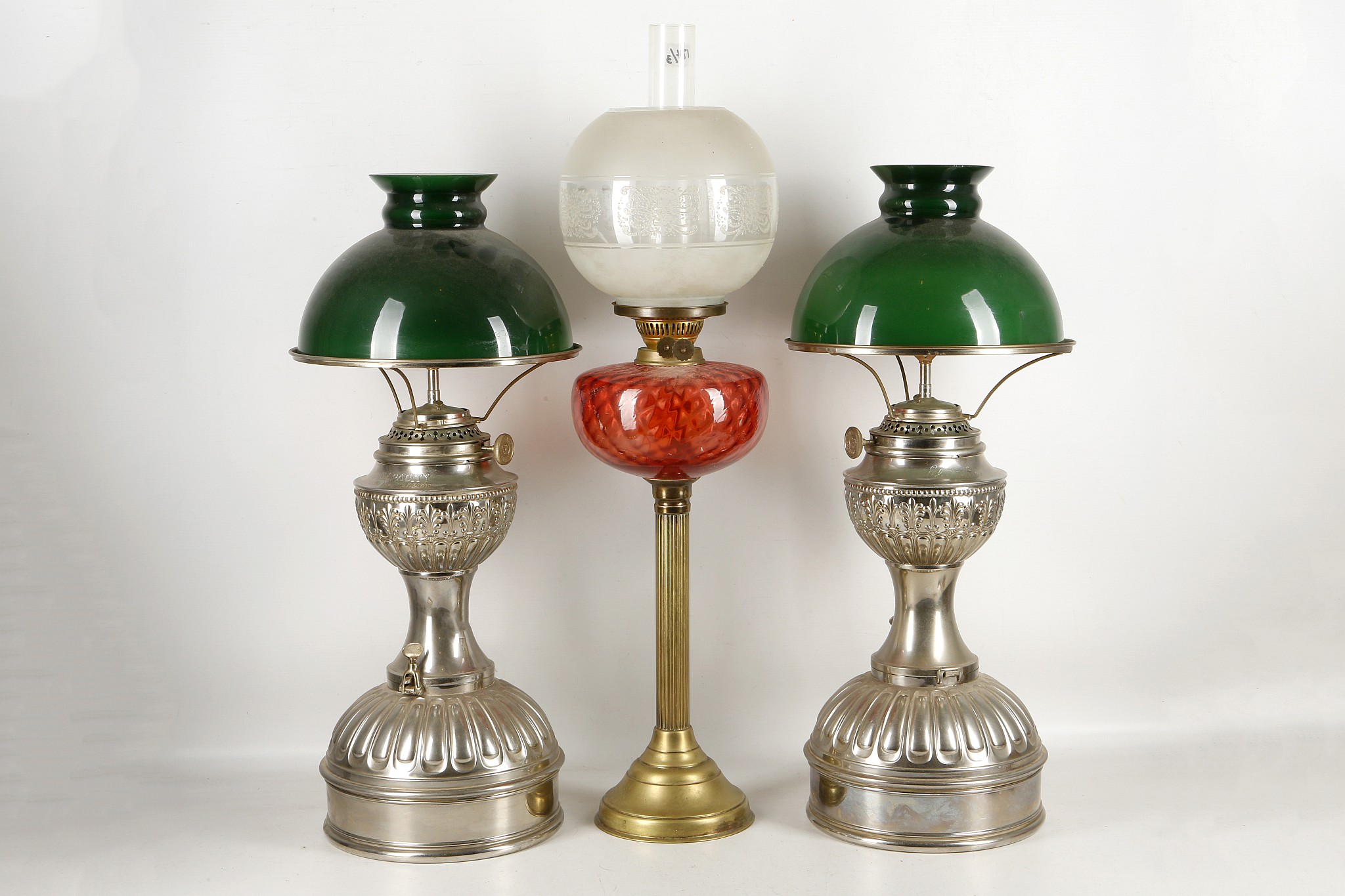 An 'Electrolite' pair of oil lamps, green 'bankers' shades, 61cm high and an oil lamp with etched