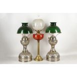 An 'Electrolite' pair of oil lamps, green 'bankers' shades, 61cm high and an oil lamp with etched