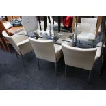 A modern glass dining table, on sculptural chrome base, with six beige leather effect chairs on
