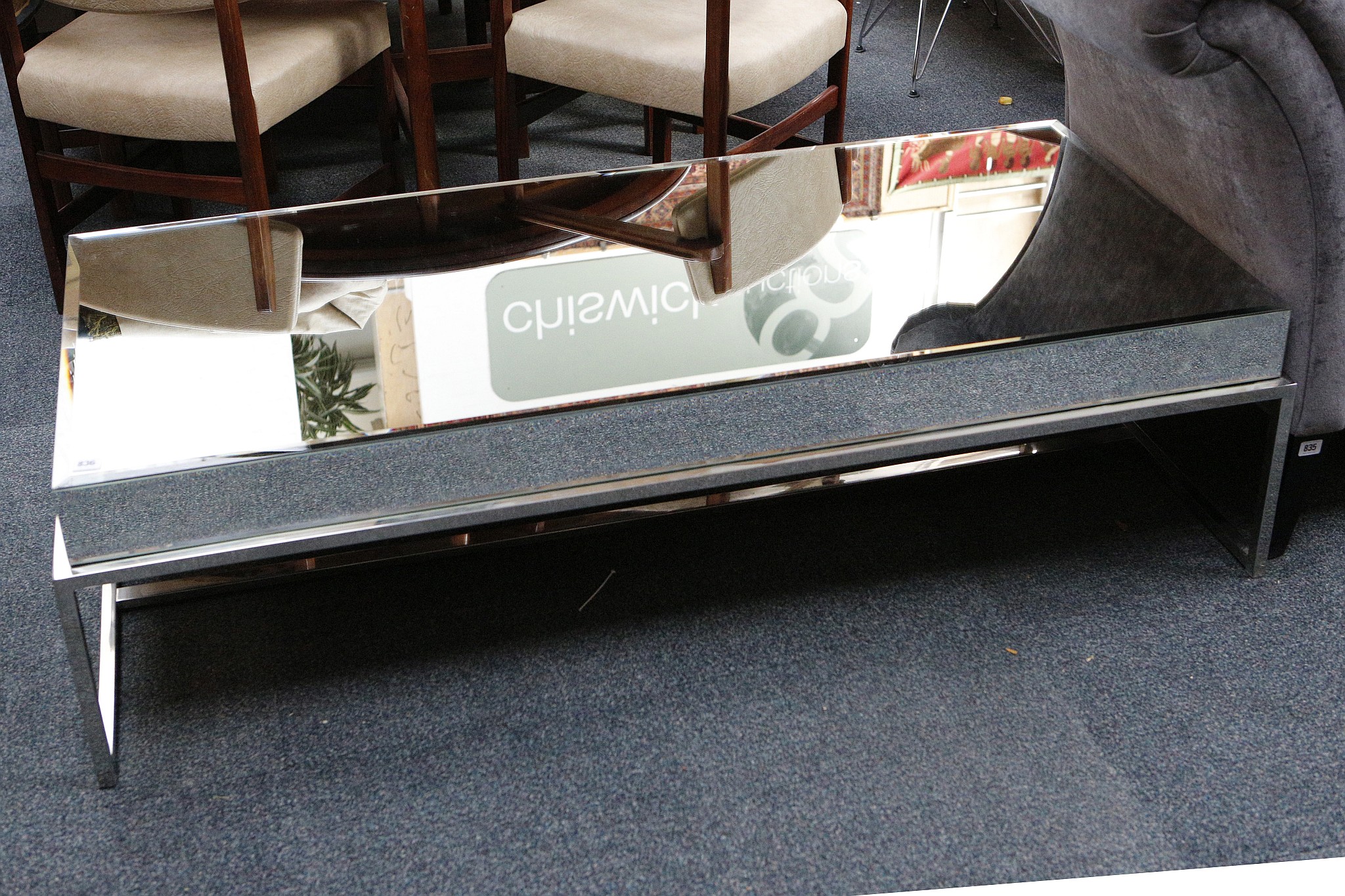 A modern mirror top coffee table, the top and sides clad with bevelled mirror, raised on chrome