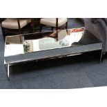A modern mirror top coffee table, the top and sides clad with bevelled mirror, raised on chrome