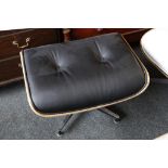 An Eames inspired ottoman, having black faux leather upholstery, raised on chrome base, 41 H x 65