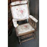 A beechwood American rocker chair, the open arms with turned spindle support and floral