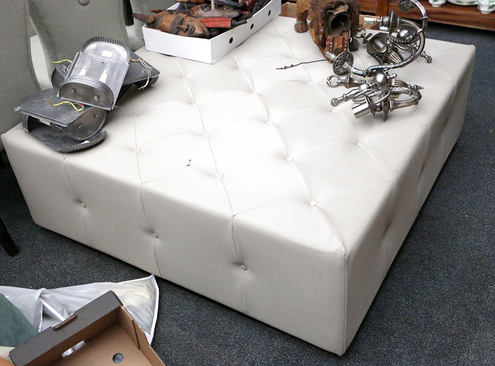 A large modern beige buttoned footstool by Jameson Furniture, on black painted wood base, 124 x