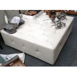 A large modern beige buttoned footstool by Jameson Furniture, on black painted wood base, 124 x