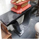 A modern console table, with black mirrored glass top, on 'U' shaped support, 117.5 x 31.5cm.