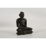 A JAIN BRONZE SCULPTURE OF TIRTHANKARA. 17th / 18th Century. Seated in dhyanasana on a throne, the