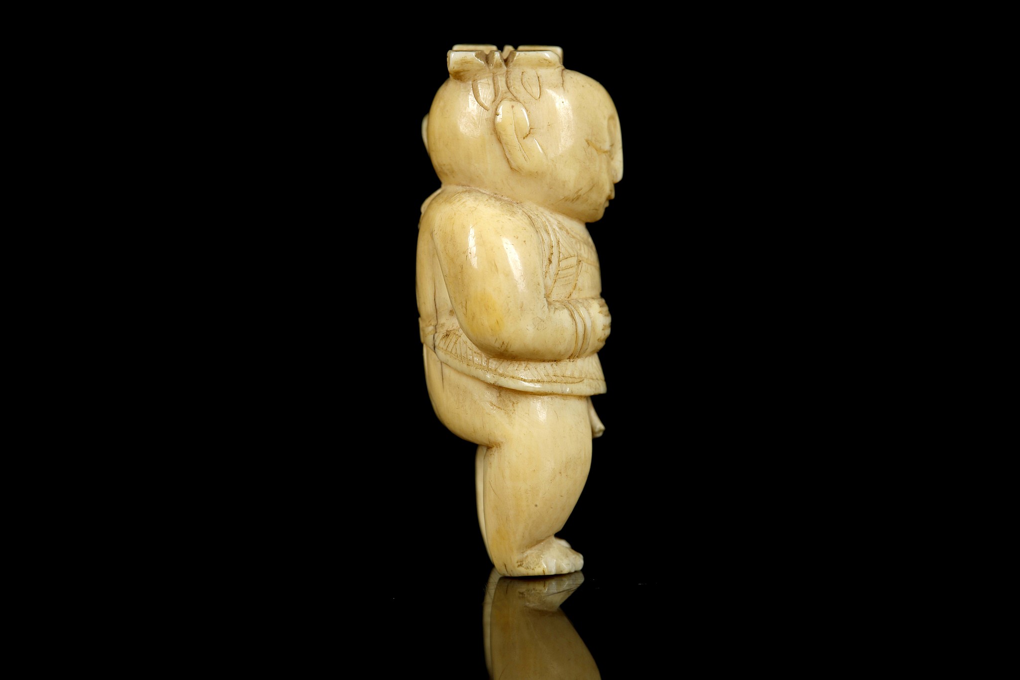 A JAPANESE IVORY NETSUKE FORMED AS A BOY. Meiji Period. Carved standing and holding a lotus - Image 2 of 6