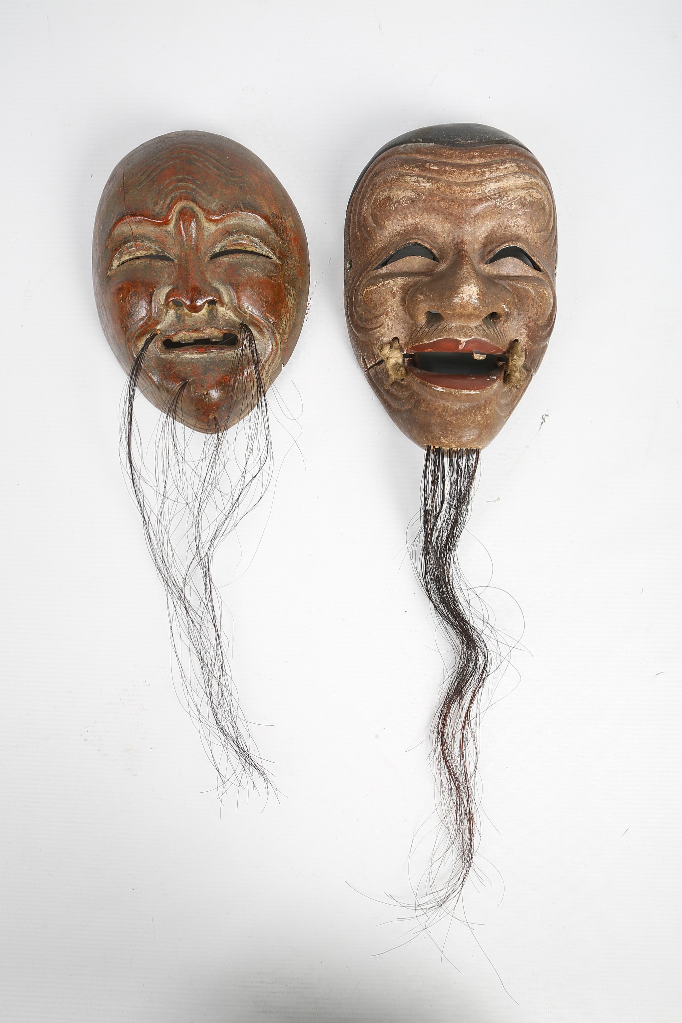 TWO JAPANESE WOODEN MASKS. Meiji era. 19cm H. (2) Provenance: John Marriott (1921-2007) and Count R.