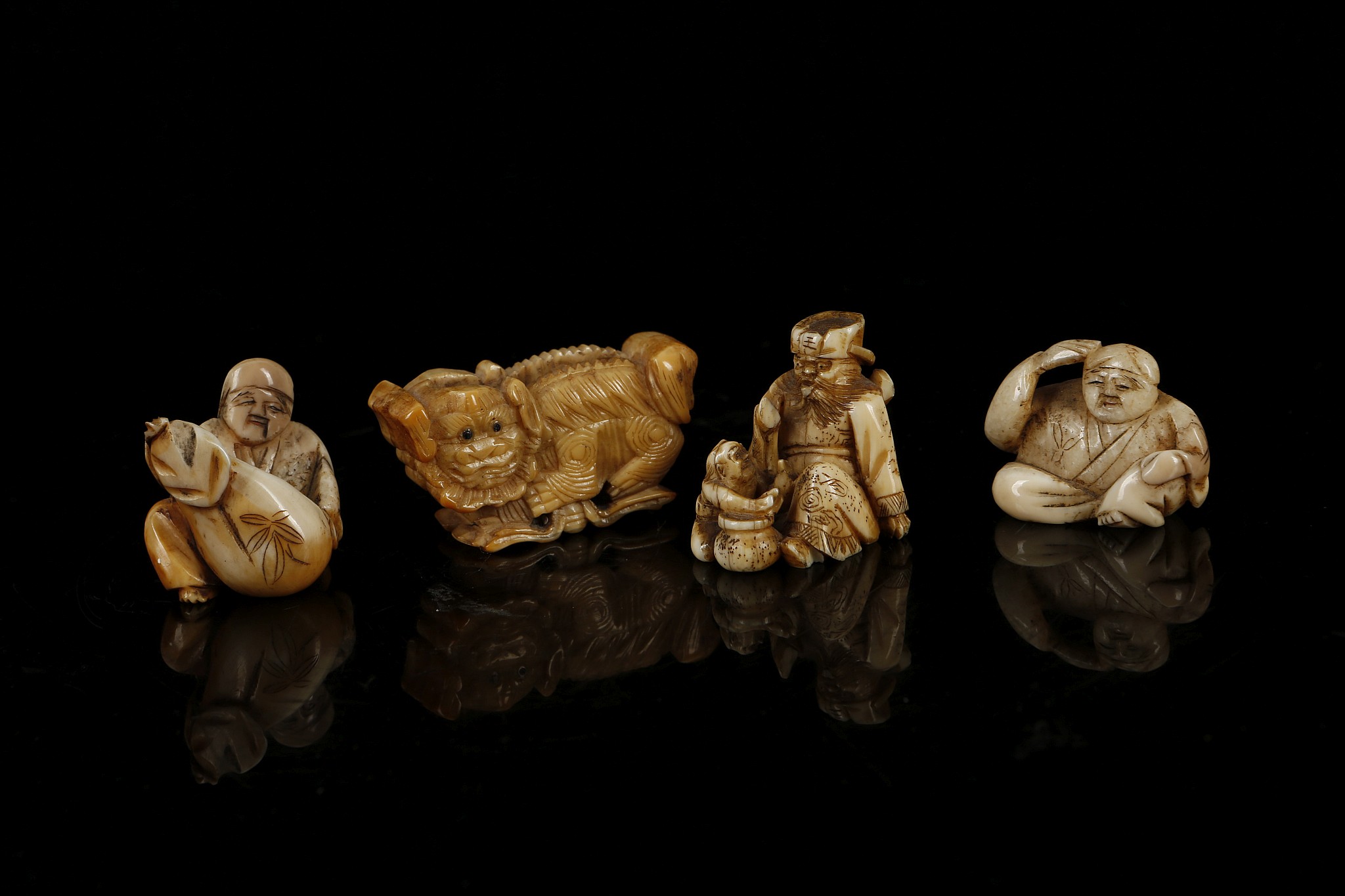 A COLLECTION OF FOUR JAPANESE NETSUKE. Two carved ivory and two carved bone. (4)