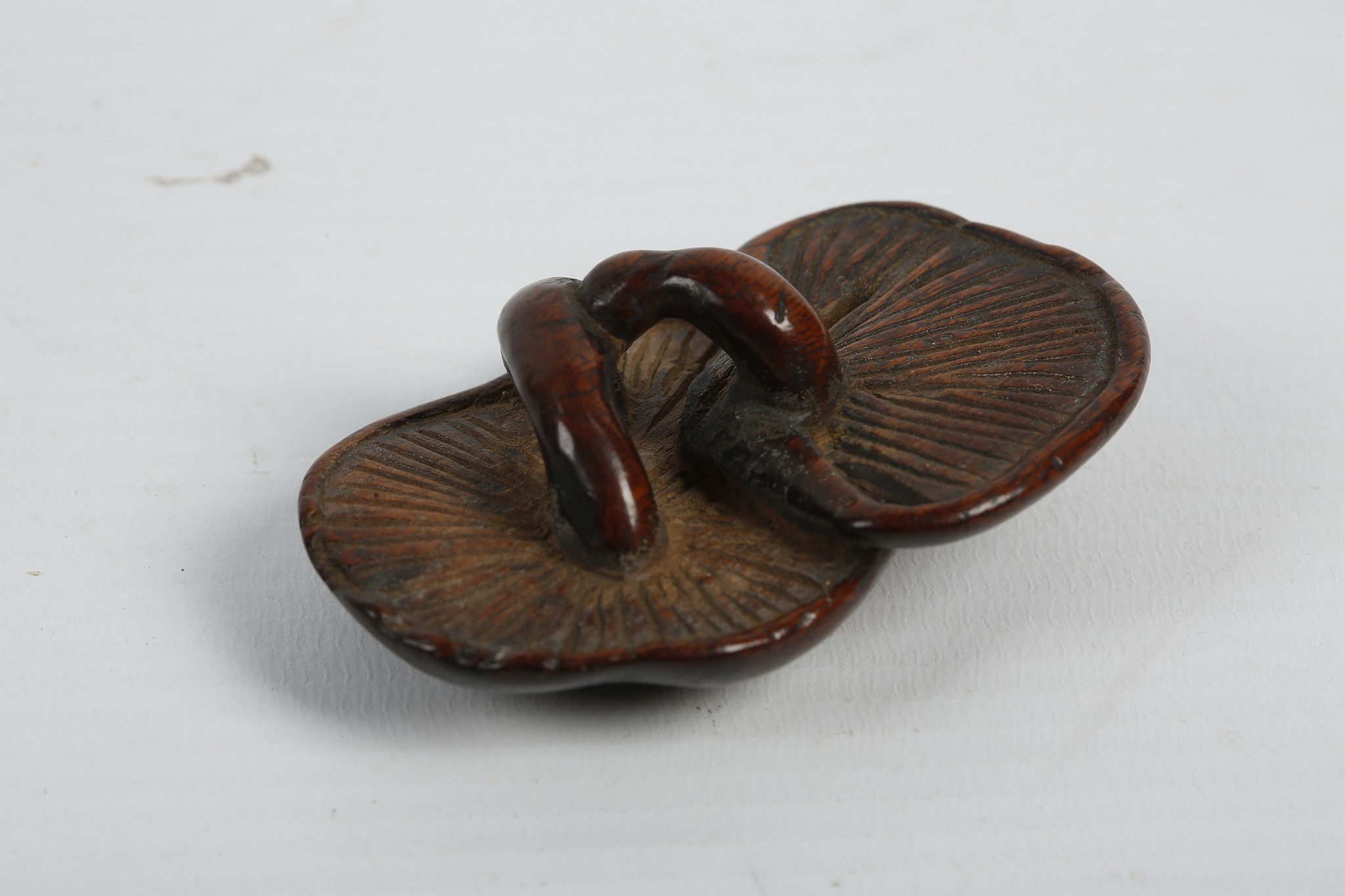 A JAPANESE WOODEN NETSUKE. Edo - Meiji Period. Carved as two conjoined mushrooms, 6cm long.