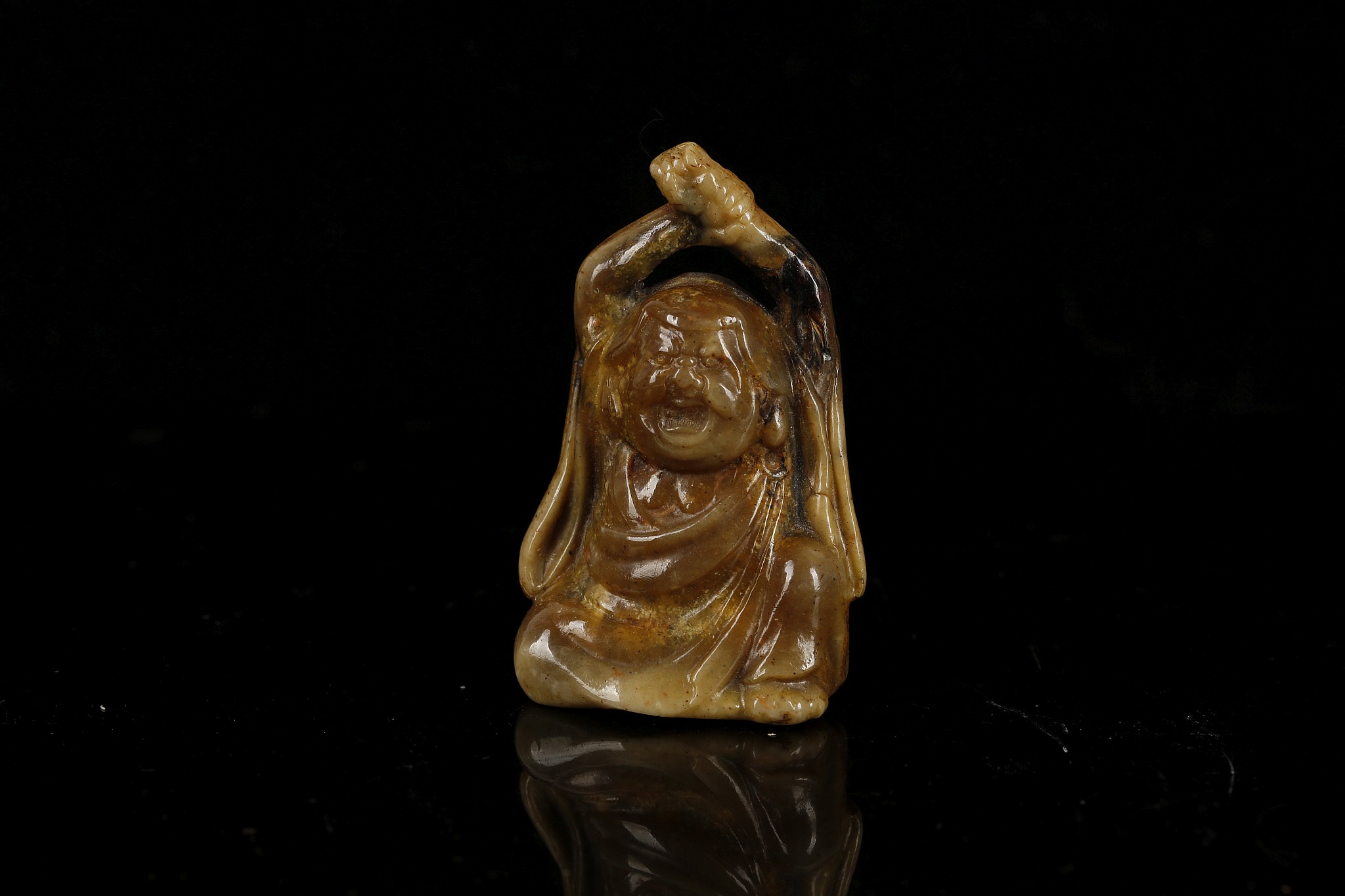 A JAPANESE AMBER CARVING OF A SEATED MAN. Late Meiji era. 5.5cm H.