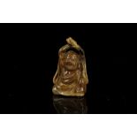 A JAPANESE AMBER CARVING OF A SEATED MAN. Late Meiji era. 5.5cm H.