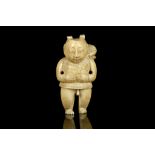 A JAPANESE IVORY NETSUKE FORMED AS A BOY. Meiji Period. Carved standing and holding a lotus