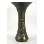 A Japanese bronze vase, decorated with a man playing bubbles, 25cm high.