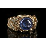 An 18ct gold, cabouchon sapphire and diamond floral scroll ring.