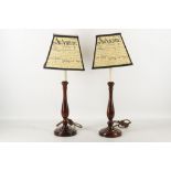 A pair of turned mahogany table lamp bases with shades.