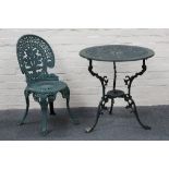 A 20th century circular iron garden table and single chair, both having pierced design top and chair