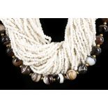 A polished agate necklace, the beads interspersed with small gilt metal beads and sold together with