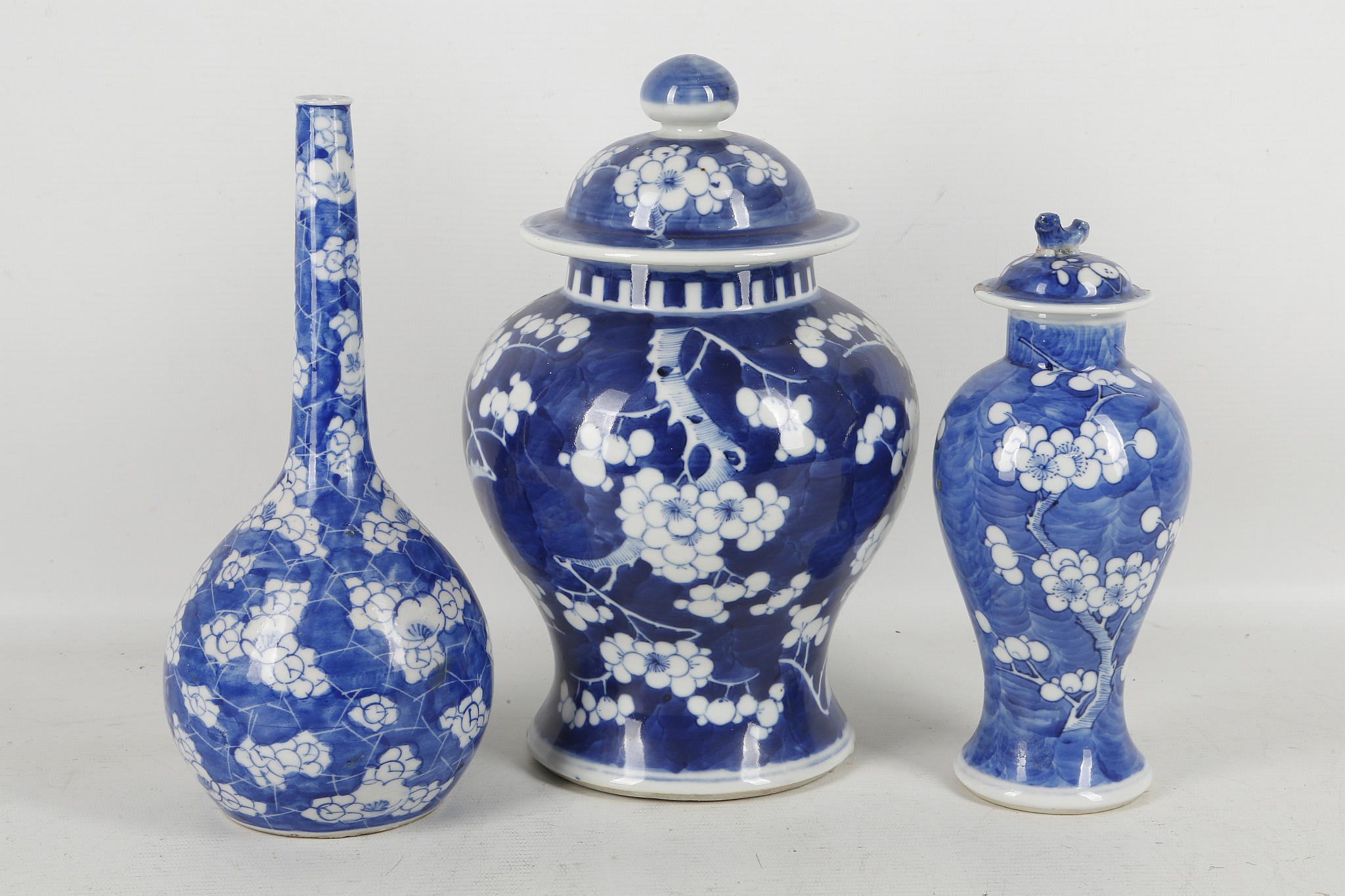 Three Chinese blue and white prunus decorated vases, two of baluster form with covers, one of pear