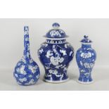 Three Chinese blue and white prunus decorated vases, two of baluster form with covers, one of pear
