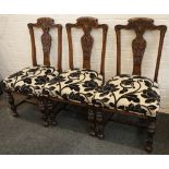 A set of six 20th century oak dining chairs, with carved and shaped top rails and vertical splats,