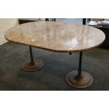 A large oval Sienna marble topped garden table, with twin iron scroll supported arms on vertical